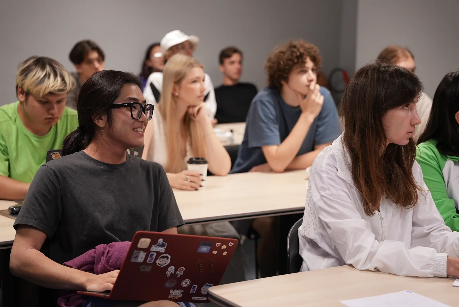 Students listening with laptops at the ready